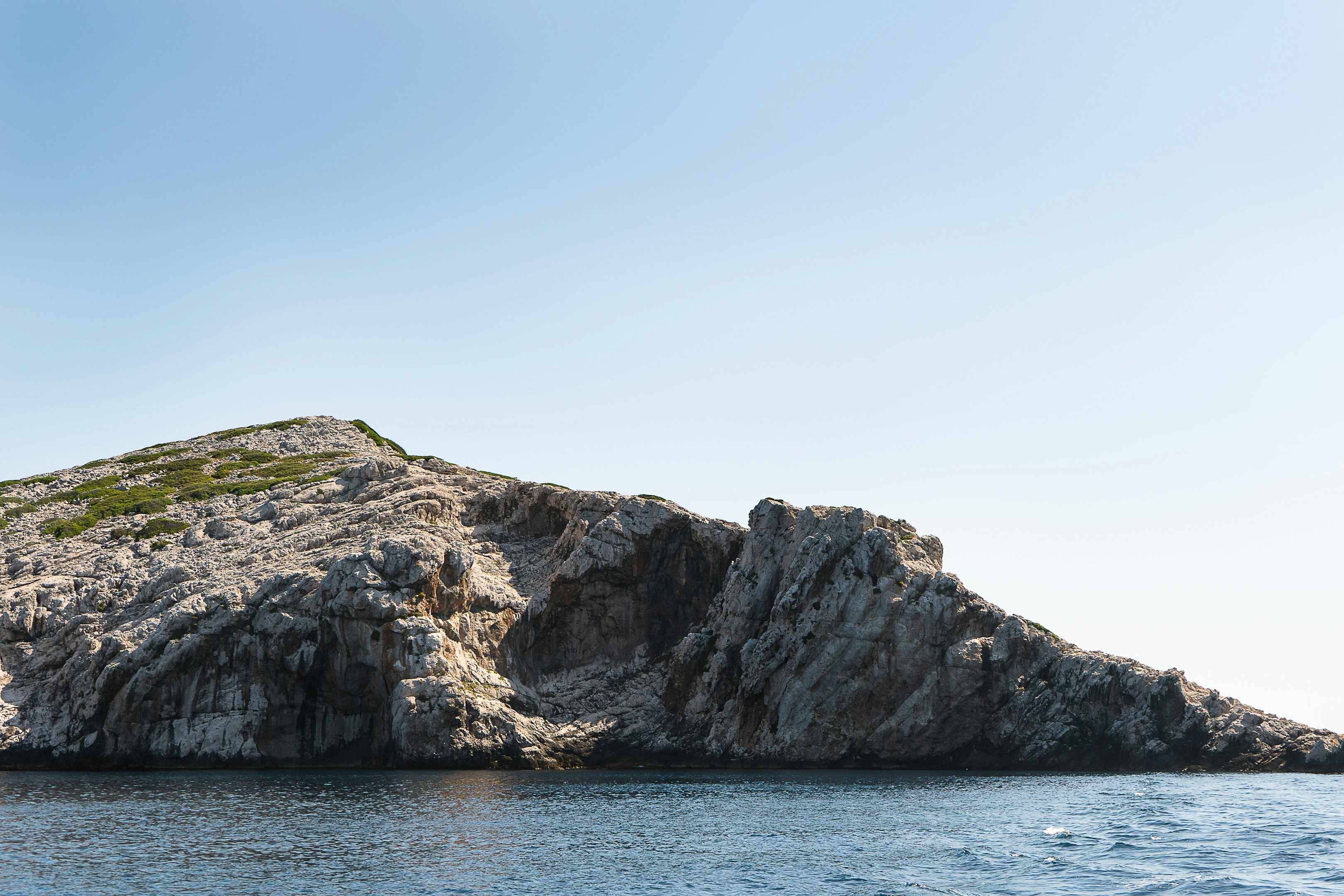 gray rock formation on body of water during daytime